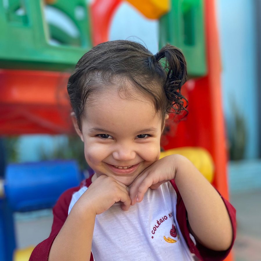 Criança sorrindo no parquinho do Colégio Nena Kids