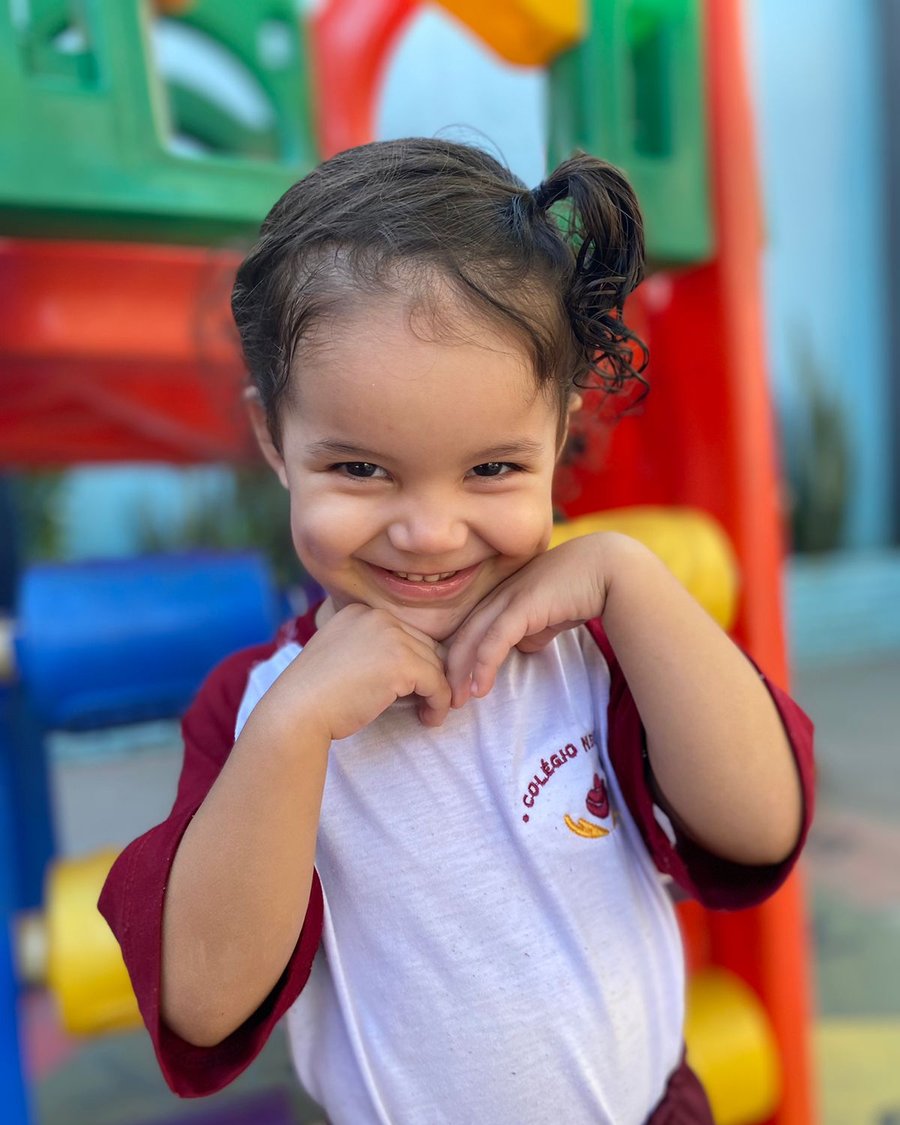 Criança sorrindo no parquinho do Colégio Nena Kids